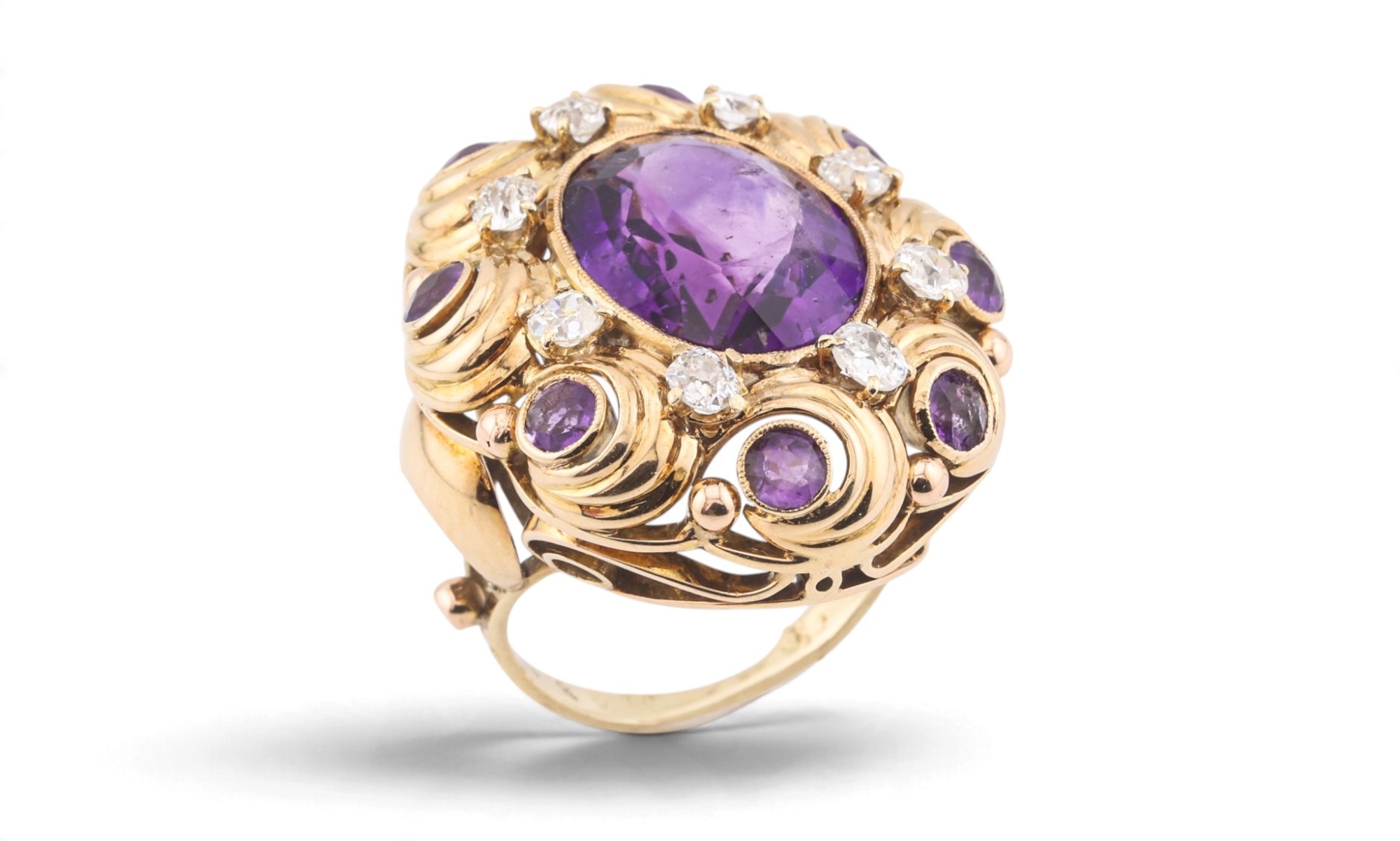 An amethyst and diamond cocktail ring in yellow gold, photographed on white