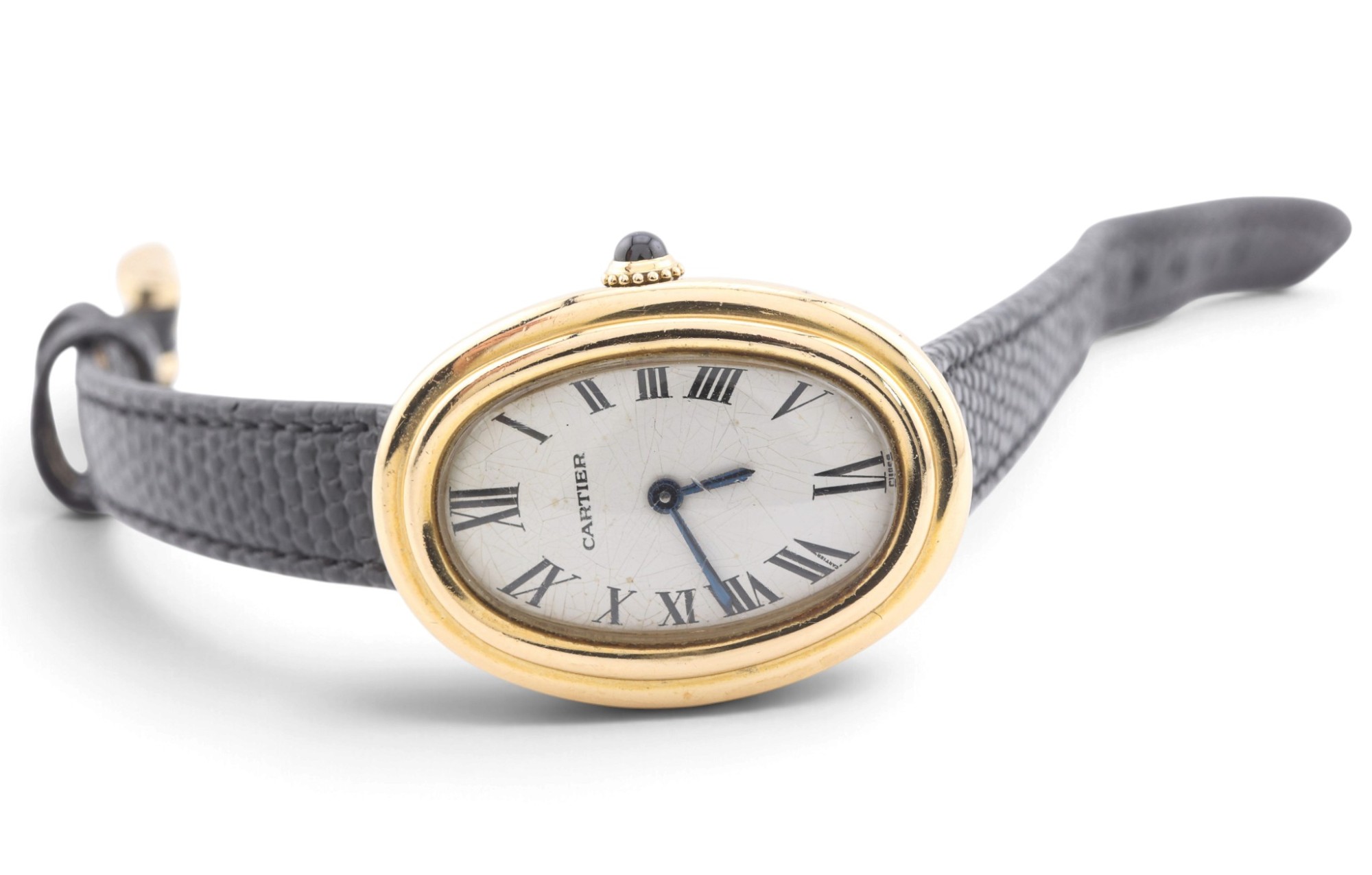 A Cartier Baignoire wristwatch in yellow gold on a grey strap, photographed on white