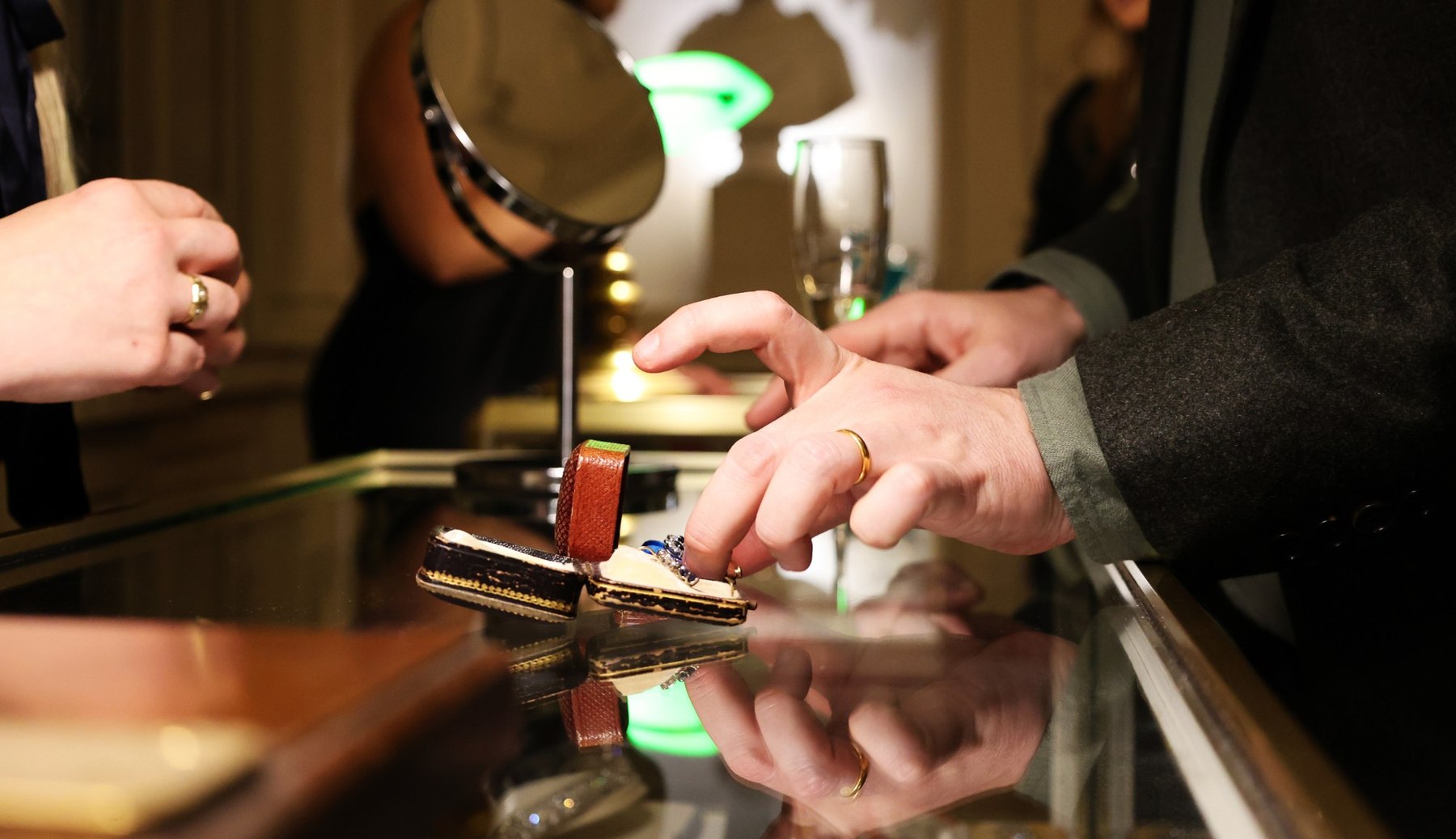 Hands examining an antique ring across a jewellery counter
