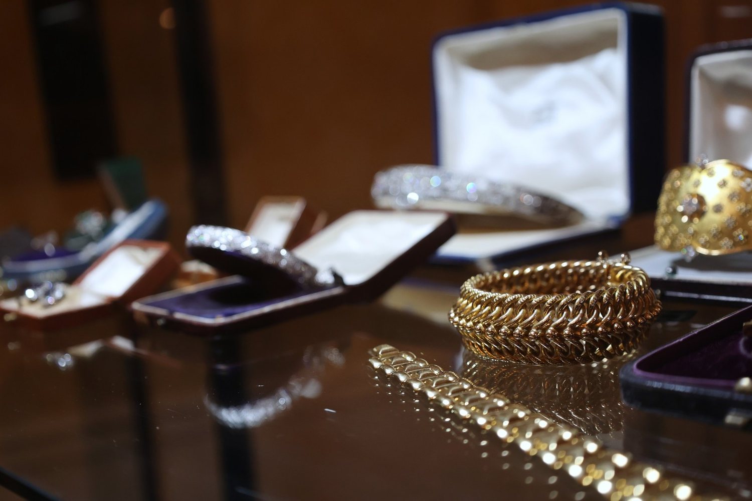 Gold bracelets and fitted cases on a polished table