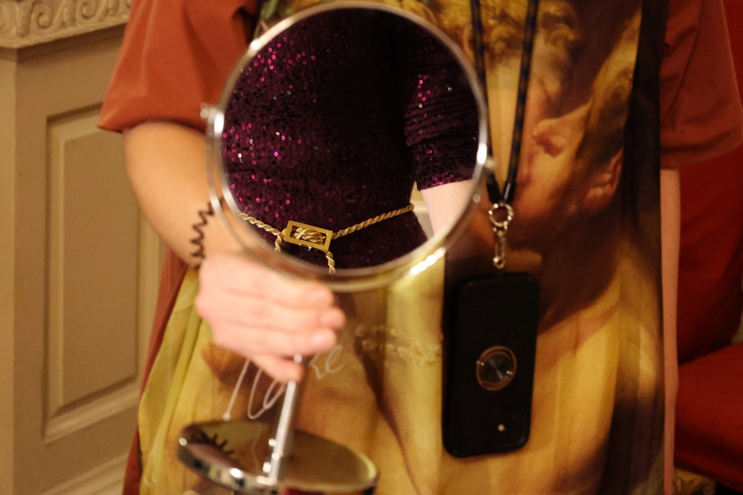 A gold rope belt reflected in a hand mirror at a selling exhibition
