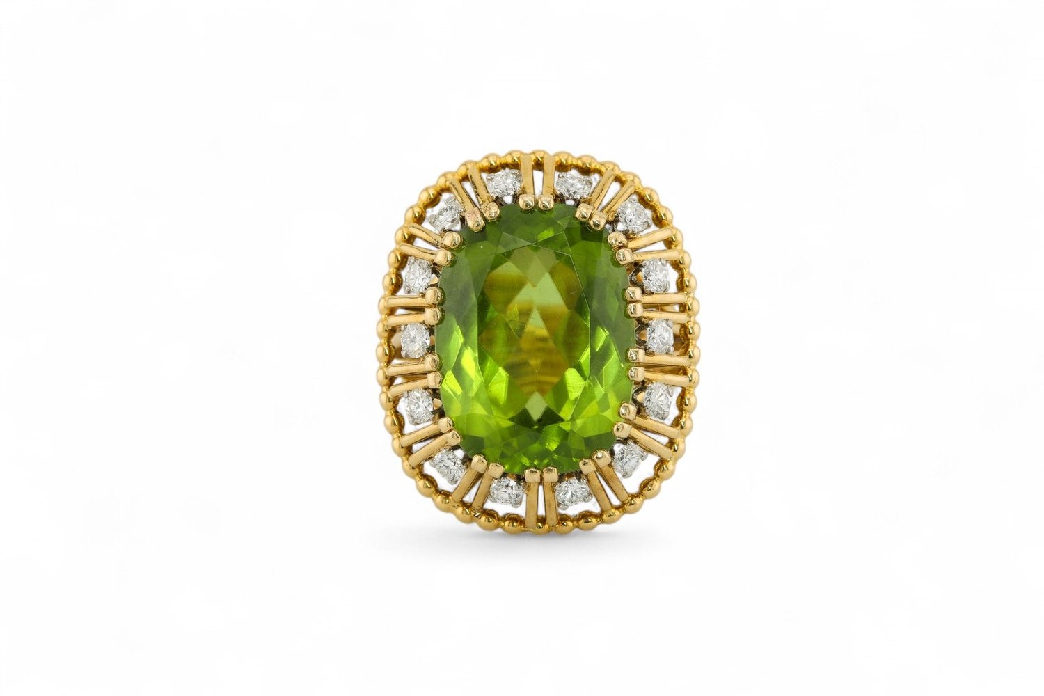 A peridot and diamond ring in yellow gold, photographed on white