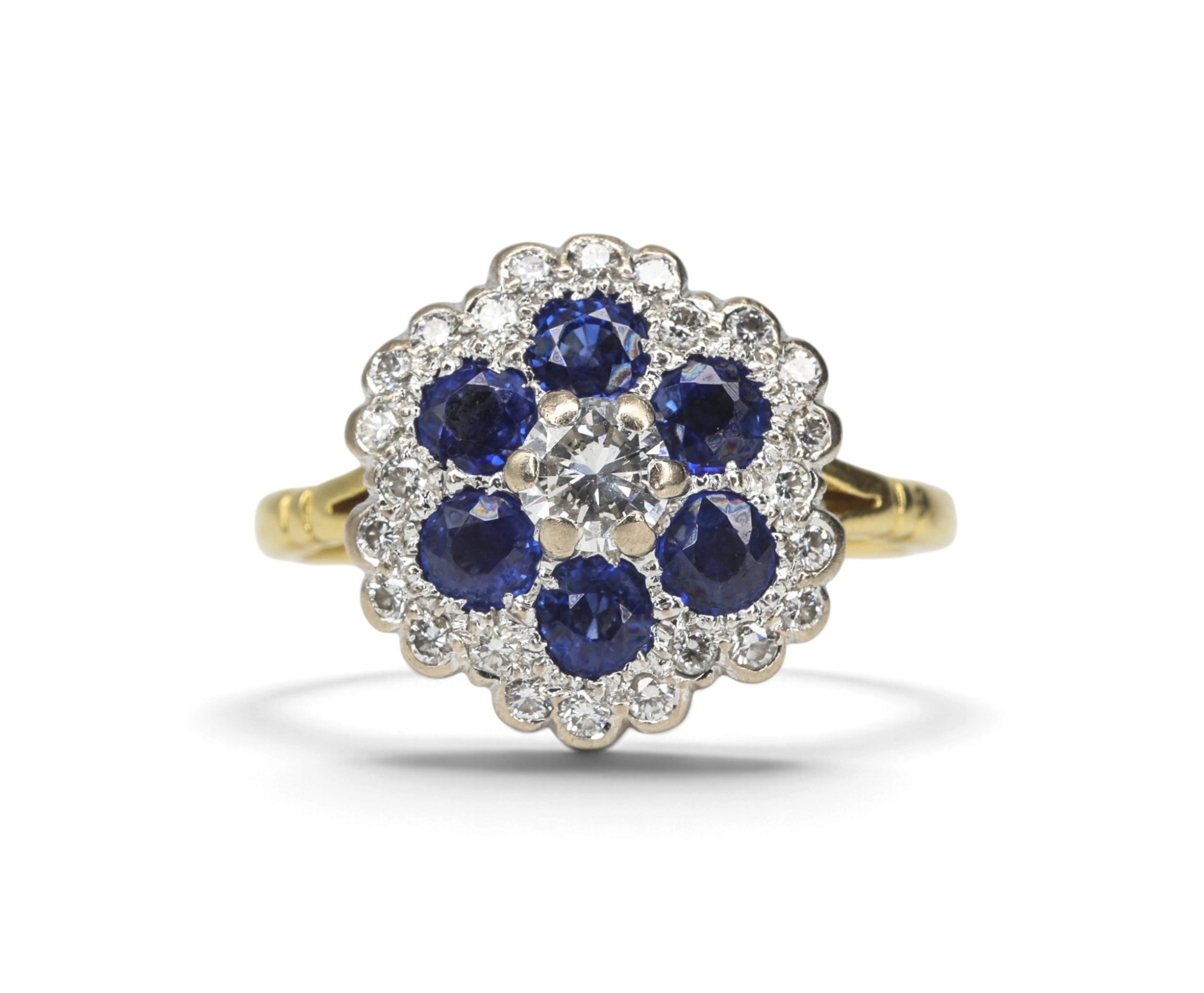 A sapphire and diamond flower cluster ring, photographed on white